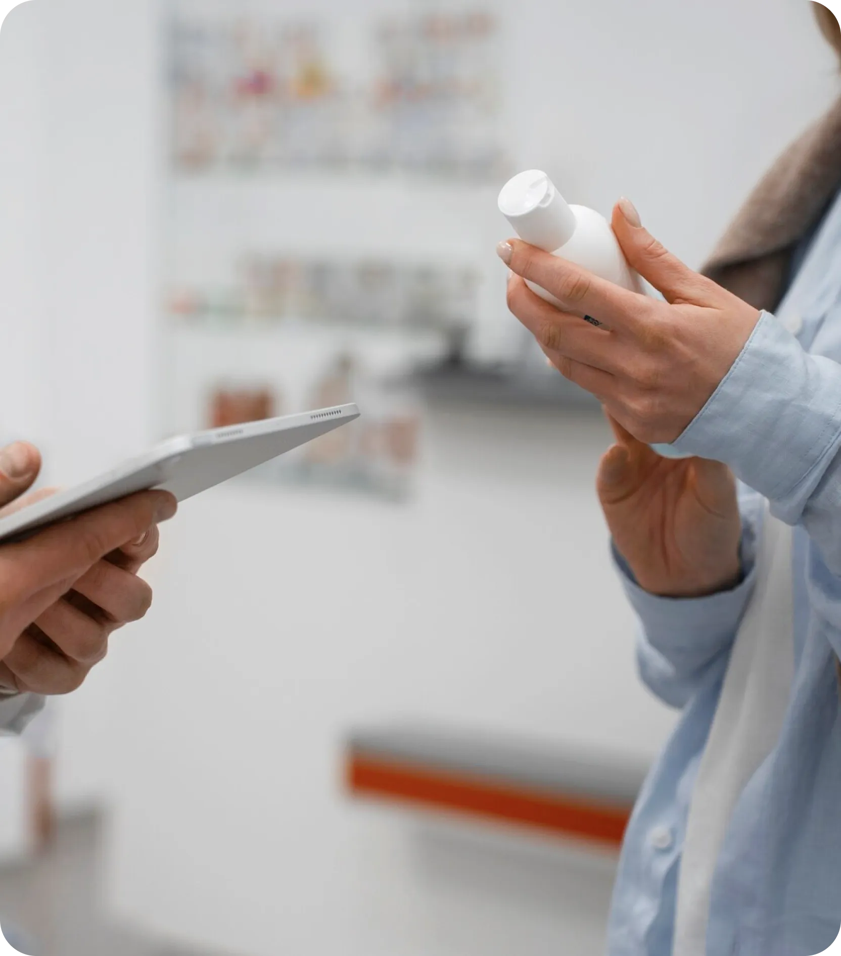 A man stands with a tablet in one hand and a medicine bottle in the other, demonstrating a moment of concentration.